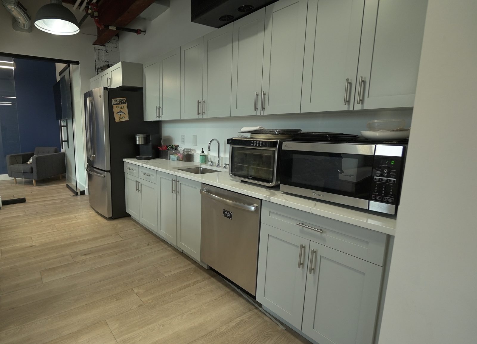 The coffee bar at The Node: a run of cabinets with a coffee machine, sink, microwave and full-height fridge