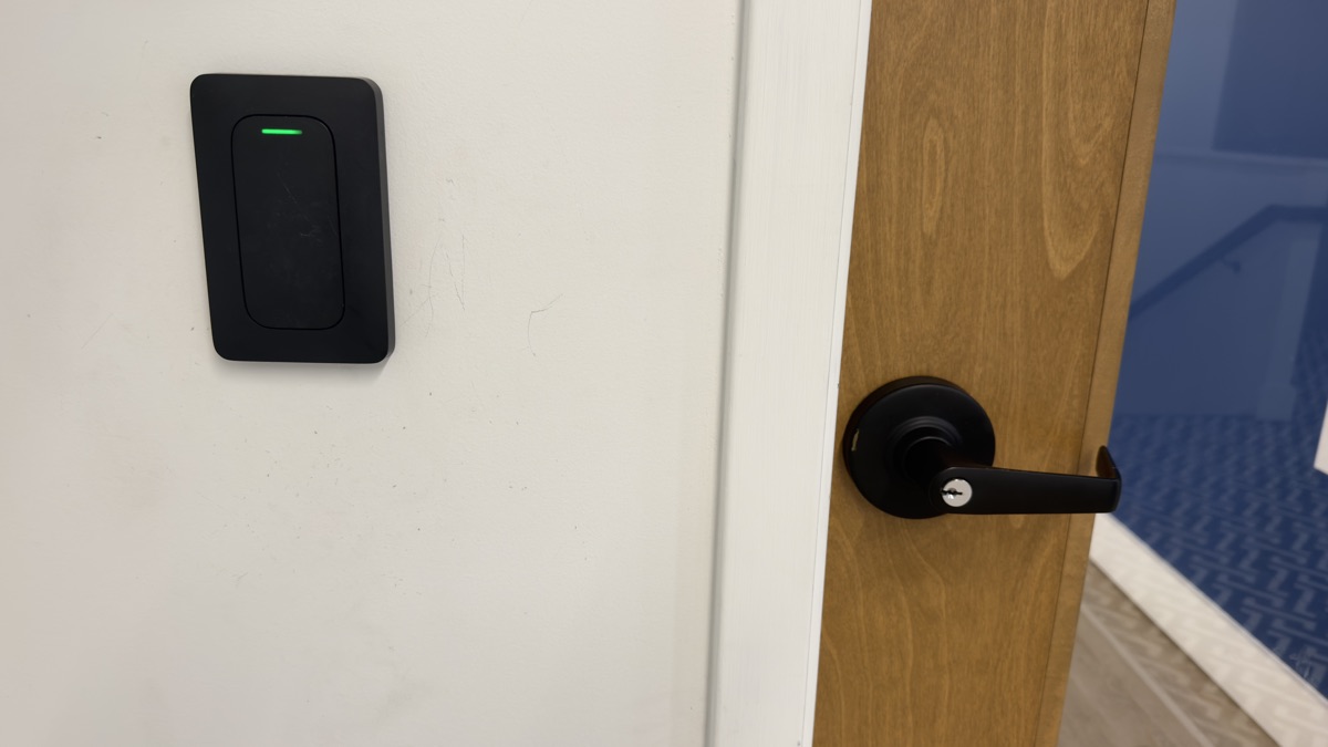 A Verkada card reader mounted beside the suite door, status light green